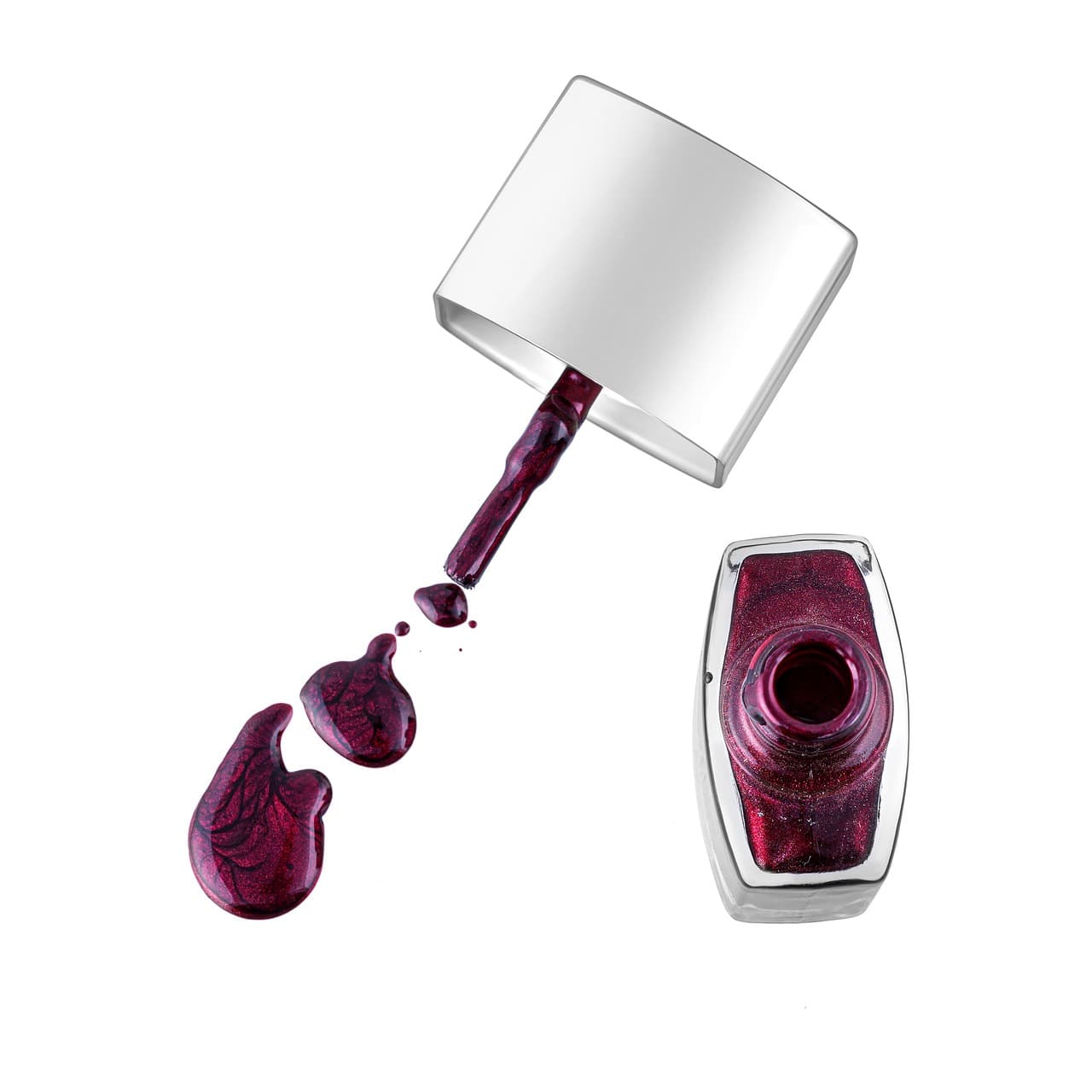 An open bottle of deep berry nail polish and its brush, with drops of the polish on white
